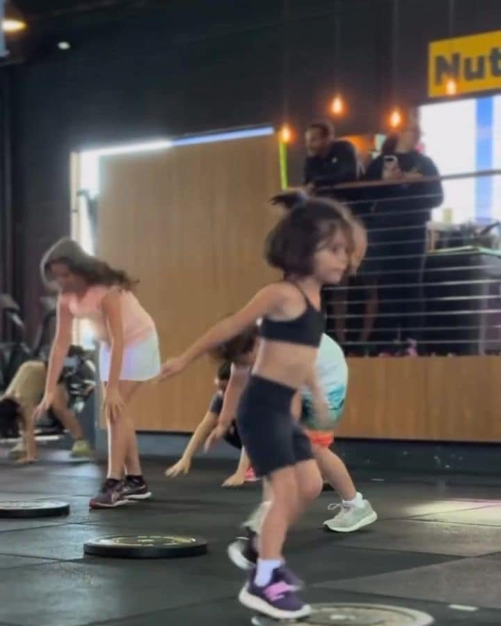 Crianças fazendo exercício sobre anilhas na aula de CrossFit Kids